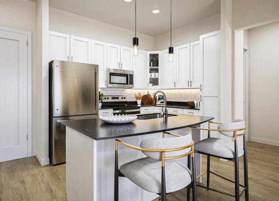 a kitchen with a center island with three stools